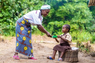 Volunteer in Liberia serving Mary's Meals to child